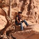 Model-posing-near-solitary-tree-in-the-upper-reaches-of-Petra.-She-looks-out-towards-Israel