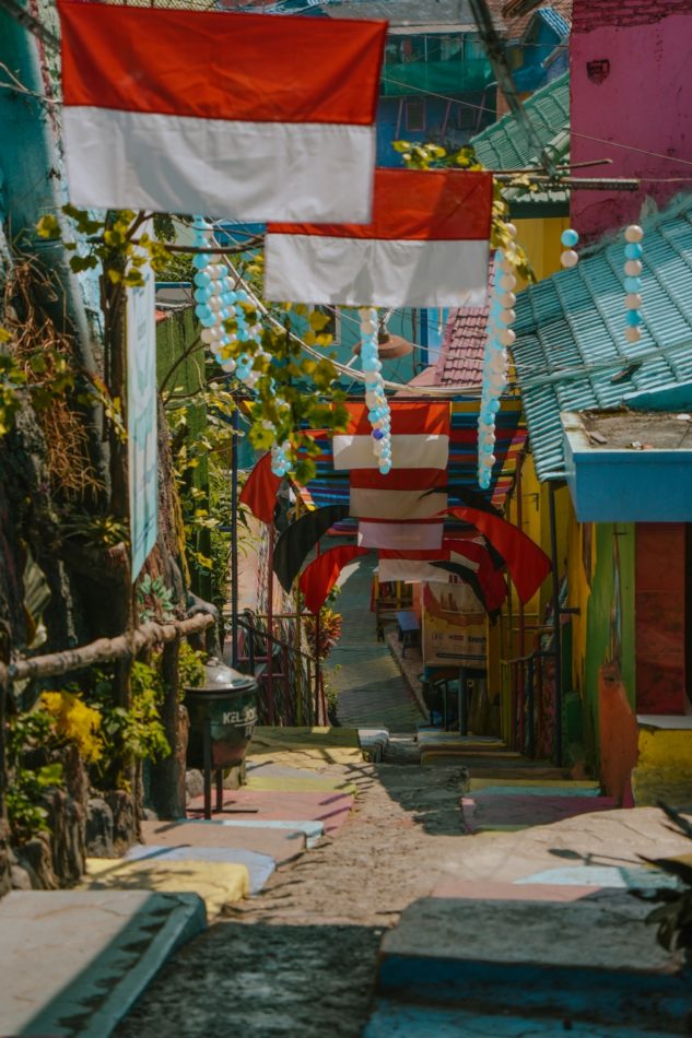 rainbow street in Jodipan Village with Indonesian flags and painted walls