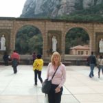 woman standing in front of white statue and mountain in montserrat spain
